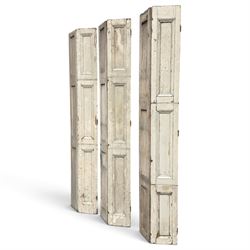 Set of three French 19th century painted pine folding window shutters of tall form, each comprising two hinged leaves with three graduated raised and fielded panels, in antique cream-painted finish