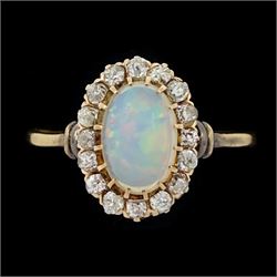 Gold opal and diamond cluster ring, single oval cut opal surrounded by sixteen old cut diamonds 