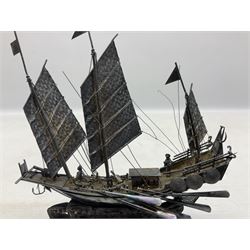 Chinese miniature silver model of a junk ship, with textured sails, mounted upon a carved wooden stand, H14cm