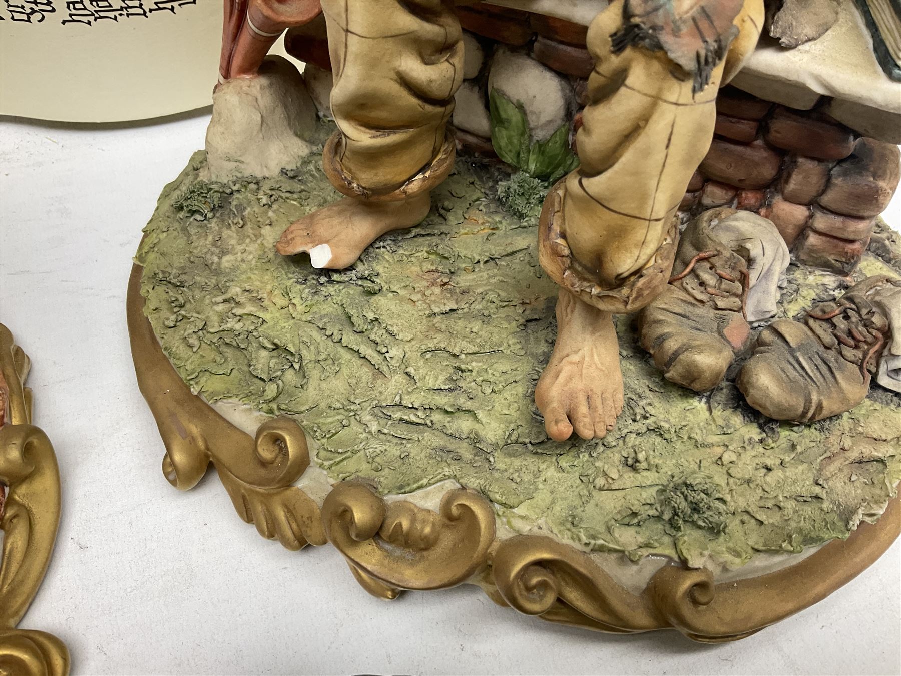 Four Capodimonte figure groups, to include tramp figures, shoemaker figure etc