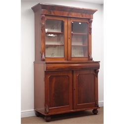  Victorian mahogany bookcase on cupboard, projecting cornice, two glazed doors enclosing shelves above single drawers and two cupboards on turned feet, W120cm, H200cm, D54cm  