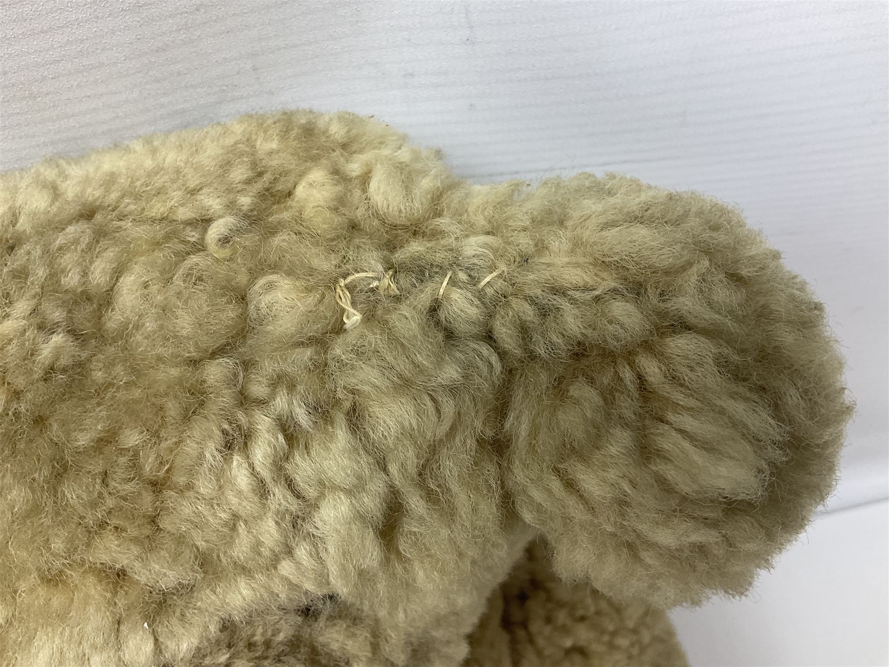 1950s sheepskin plush covered teddy bear with musical movement, the revolving head with applied eyes, leather nose and stitched mouth, jointed limbs with leather pads H50cm