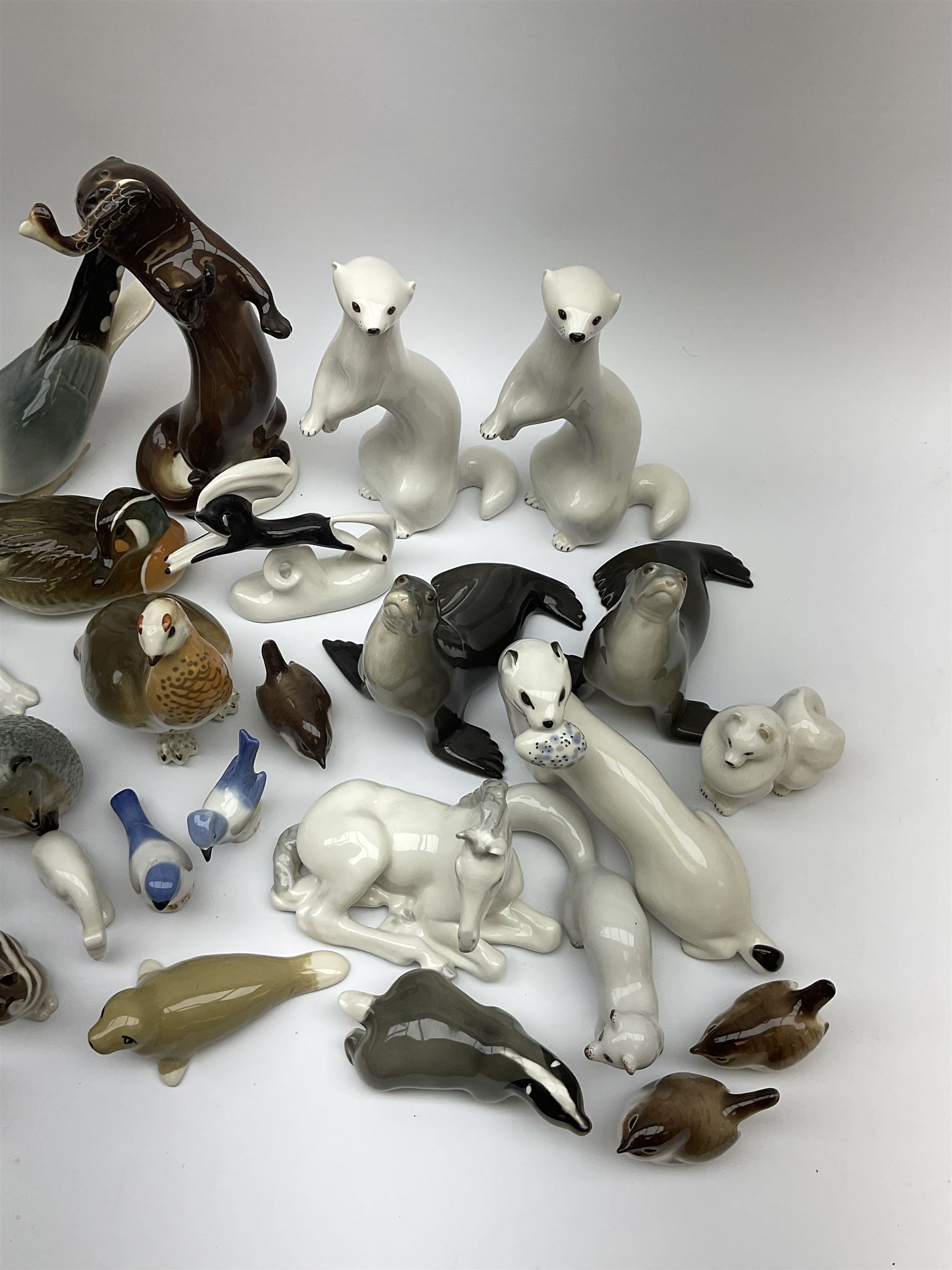 A collection of Russian animal figures, largely comprising Lomonosov examples, to include examples modelled as otters, seals, polar bears, horse, various birds, wolf, hedgehog, etc. 