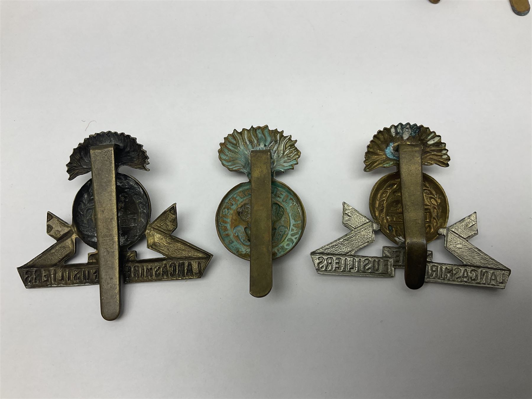 Nineteen Yeomanry metal cap badges including Derbyshire, Northamptonshire, Essex, Glamorgan, Staffordshire, City of London, Surrey, Shropshire, Hertfordshire etc; together with eleven Fusiliers badges including Lancashire, Royal Welch, Northumberland etc (30)