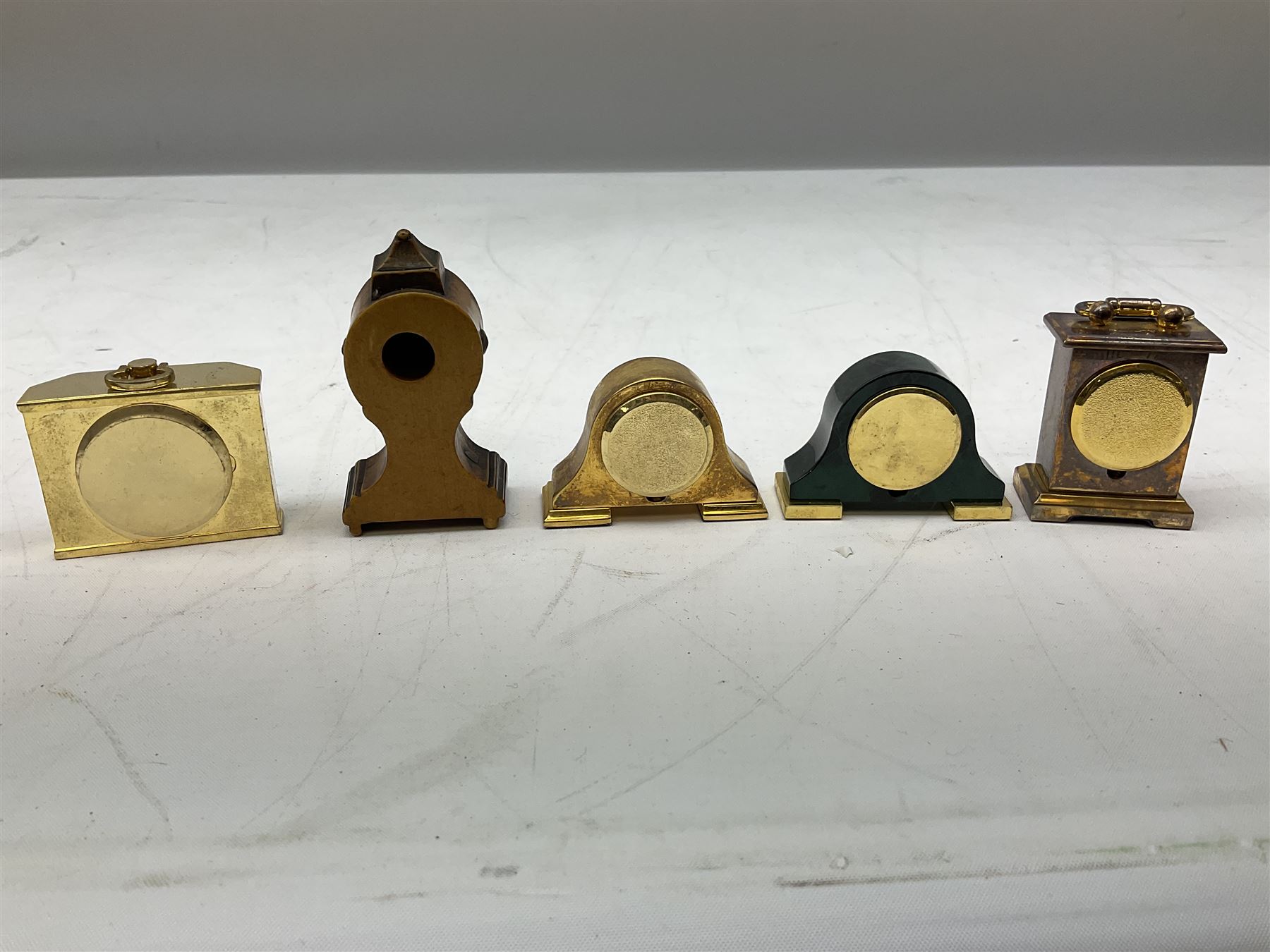 Collection of miniature clocks, predominantly with quartz movements, to include example modelled as an armchair, Edinburgh crystal glass example, clock modelled as a flower, sewing machine etc