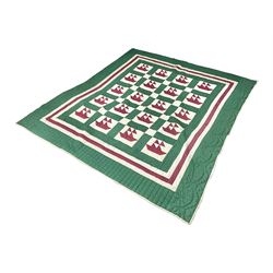 20th century quilt, with repetitive ship design to the centre within a cream red and green boarder, 227cm x 222cm