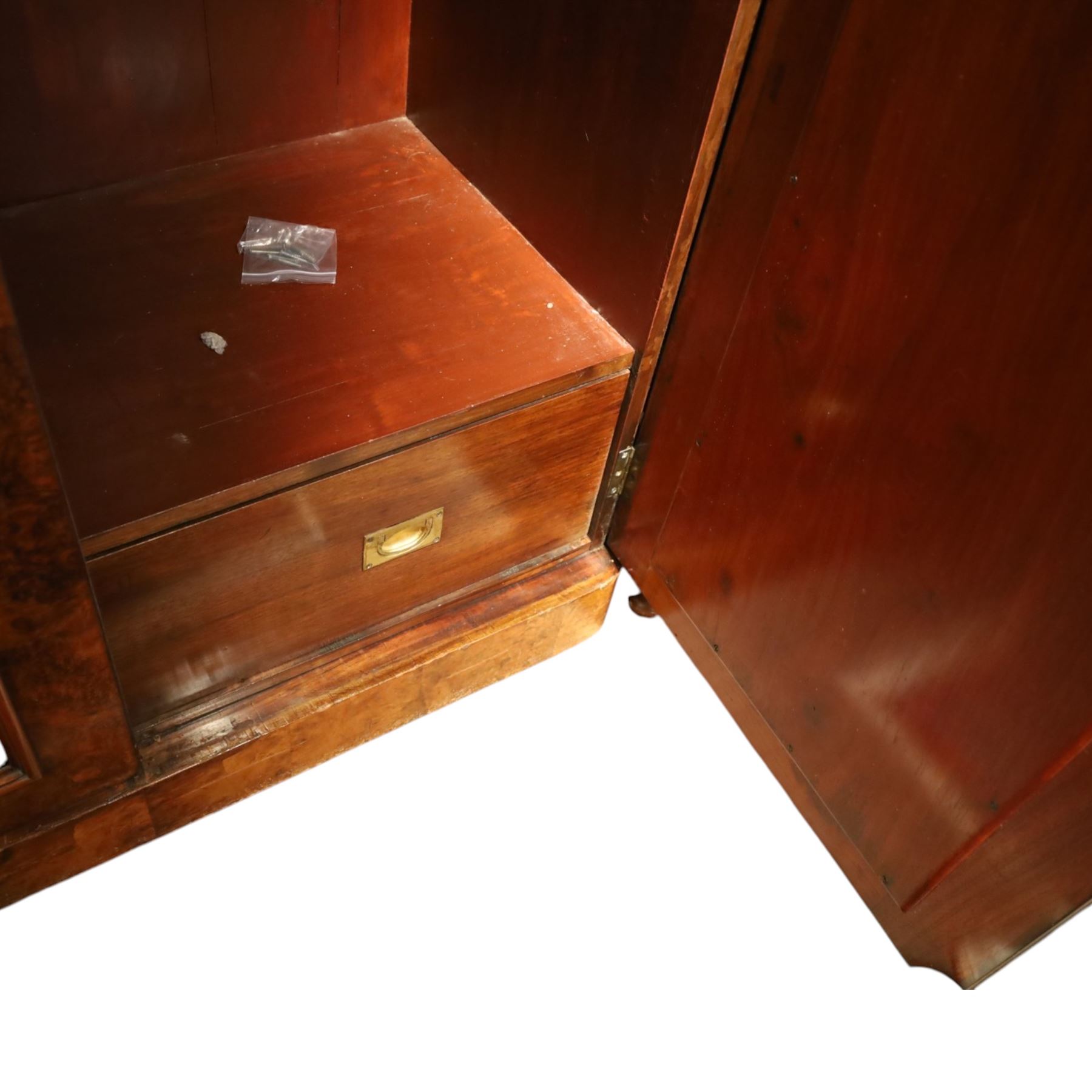 Victorian figured walnut double wardrobe, projecting moulded cornice over twin arched silvered mirrored doors, fitted with hanging rail and drawer with campaign style handle, on plinth base