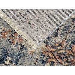 Contemporary Dunelm Soraya Persian design rug, blue and beige ground with faded floral and vine motifs, central medallion and trailing foliate patterns, bordered by a distressed design with stylised floral motifs