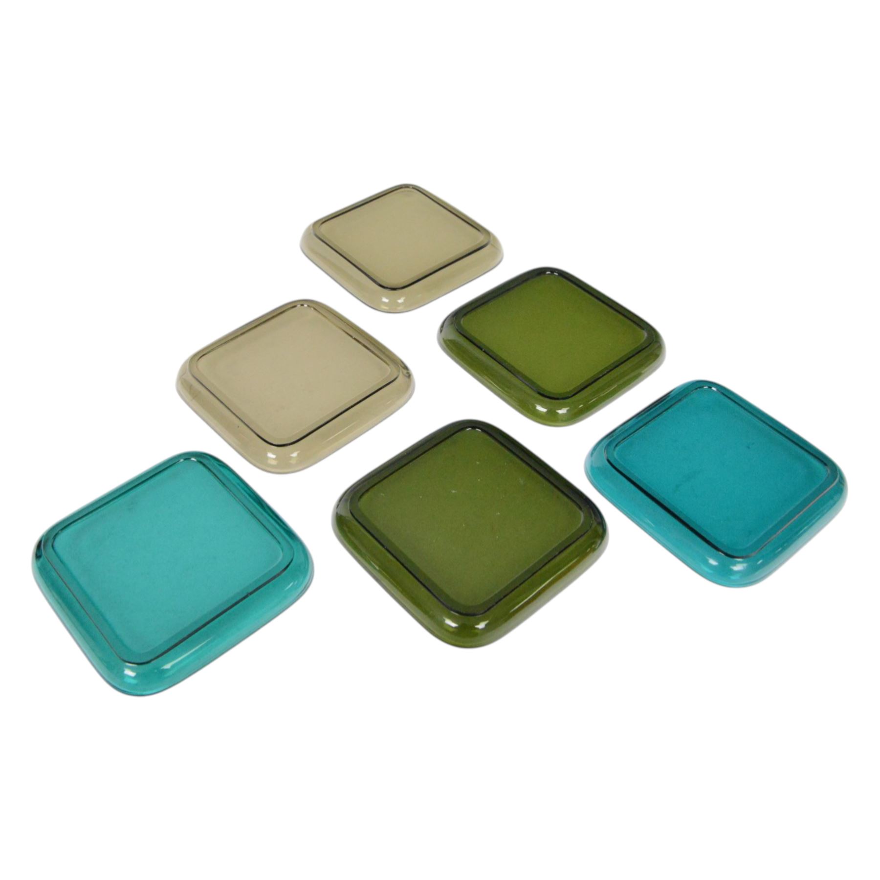 Mid century Finnish red glass bottle, designed by Nanny Still for Riihimaen Lasi, of square sided form with tall neck, H21.5cm, together with set of six mid century Finnish glass plates, designed by Kaj Franck, in smokey green, olive green and turquoise green, 13.5cm x 13.5cm