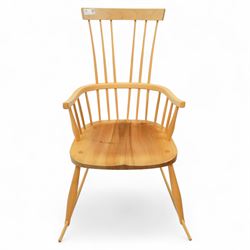 Mid 20th century Windsor ash rocking armchair, in the manner of Ercol, with curved cresting rail above nine stick spindles, shaped and chamfered paddle arms, figured shaped seat, raised on turned legs joined by twin side stretchers and mounted on curved rockers