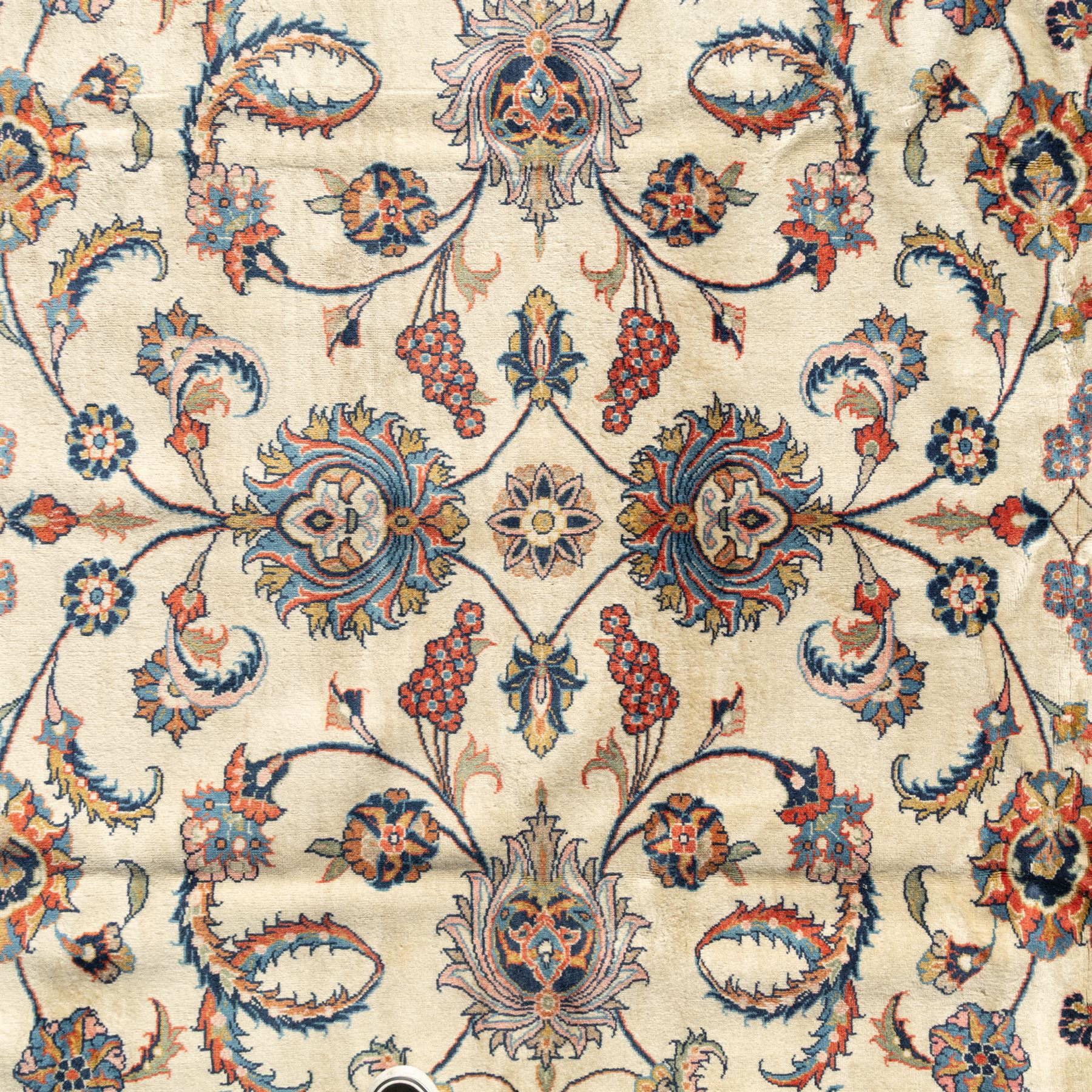Persian Sarough carpet, ivory field with symmetrical arrangement of scrolling vines, palmettes and floral sprays in red, blue and green, enclosed by a broad red main border with repeating floral motifs, originating from the Arak region of Iran