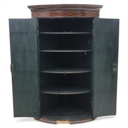 George III mahogany bow-front corner cupboard, projecting moulded cornice over satinwood inlaid frieze with geometric crossbanding, enclosed by twin shaped panel doors with line inlay and ornate brass escutcheon plates, painted interior fitted with shaped shelves, on moulded plinth base