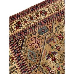 Persian Azarbaijan golden ground carpet, the shaped crimson ground medallion decorated with geometric motifs, the field profusely decorated with stylised plant and flower head motifs, repeating border with guard bands 