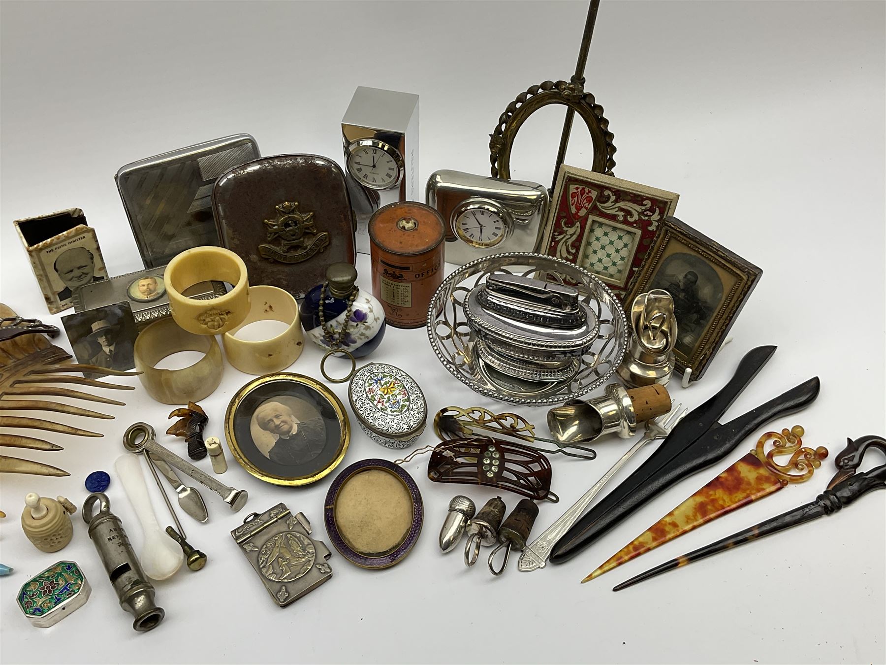 A group of assorted collectables, to include small oval purple guilloche enamel frame, WWII matchbox holder depicting Winston Churchill, Halcyon Days enamel box, Ronson table lighter, ebonised glove stretchers, ivory napkin ring, mother of pearl handled button hook, engine turned cigarette case, etc. 