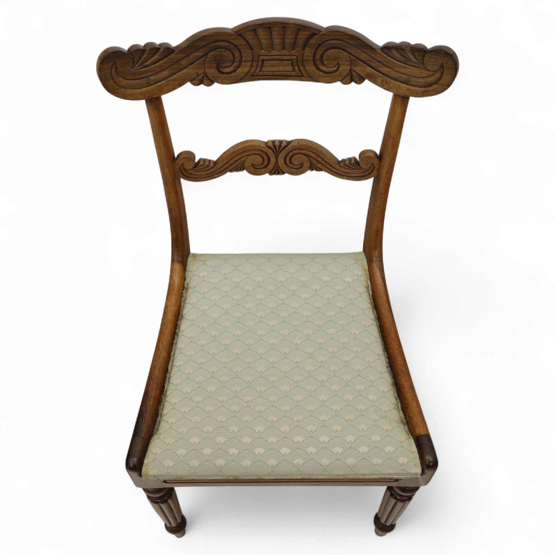 Set of four 19th-century rosewood dining chairs in the William IV style, shaped and carved top rail with fan and scroll decoration above a upholstered padded seat on reeded and turned front legs 