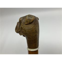 20th century walking cane, the carved wooden handle modelled as the head of a boxer dog with inset glass eyes and articulated and sprung jaw, upon a tapering Malacca shaft, L86.5cm