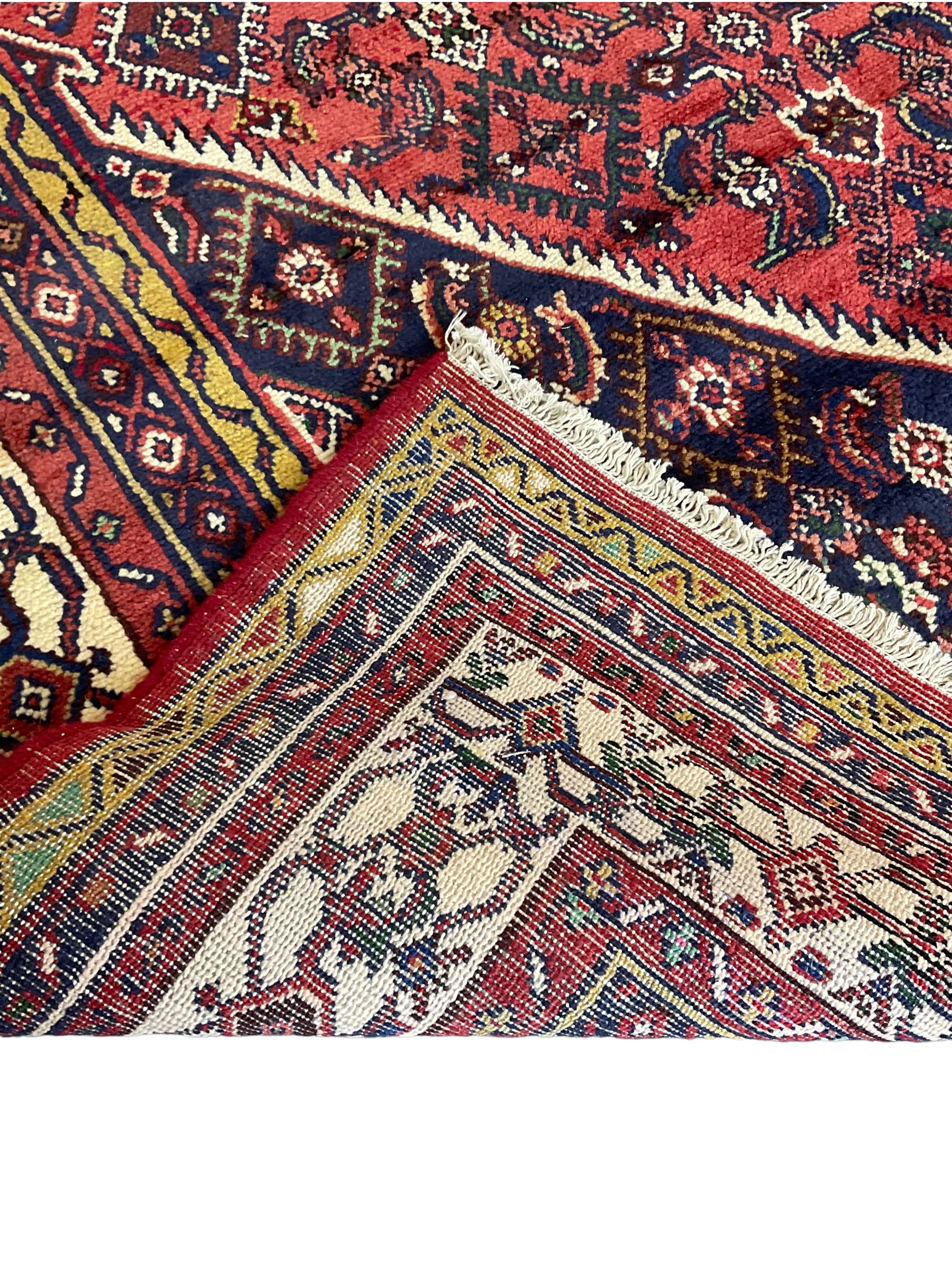 North West Persian Hamadan carpet, the extended lozenge field decorated with Herati motifs, central lozenge medallion, multiple border bands decorated with geometric designs 