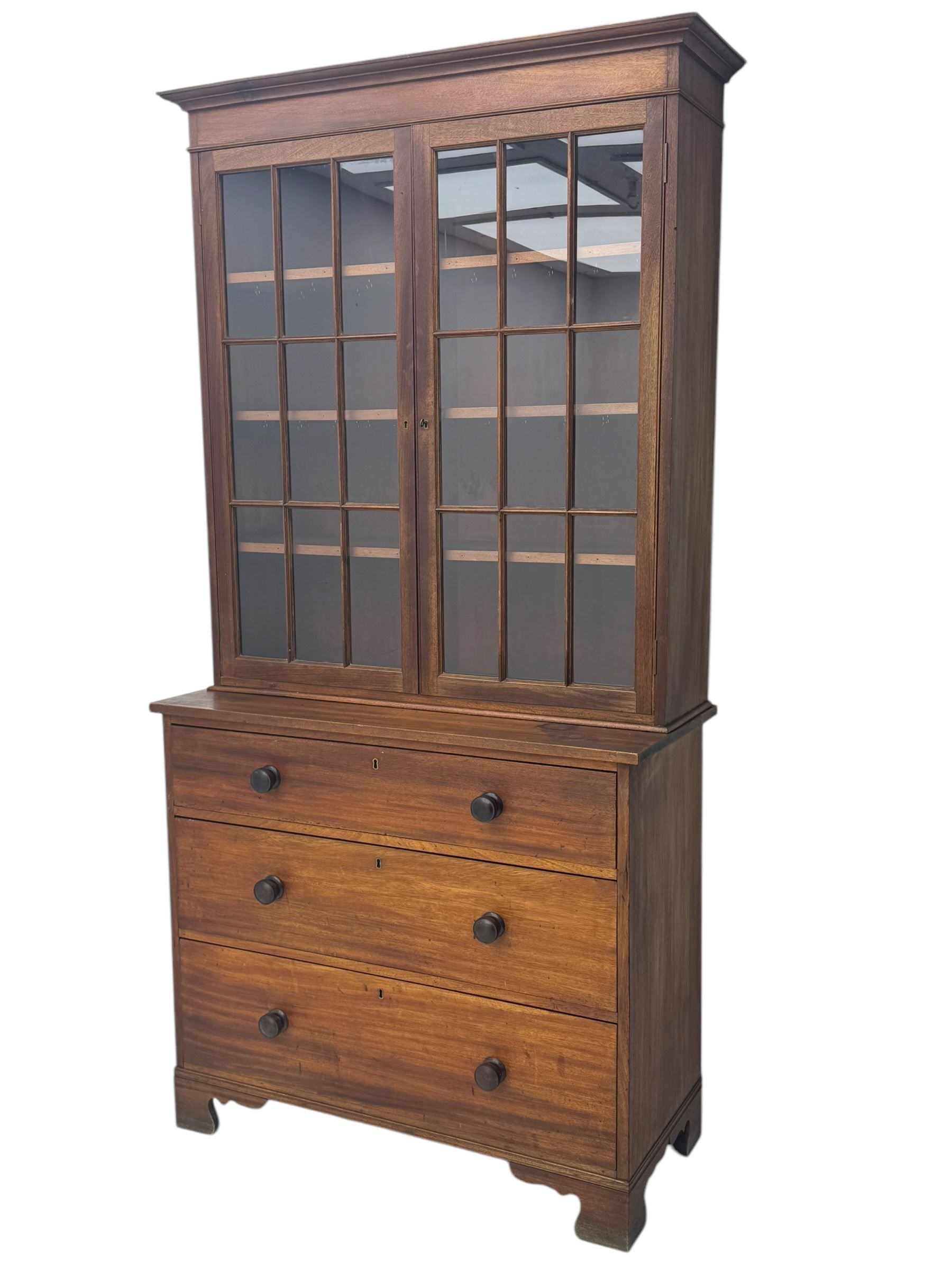 Late 19th century mahogany bookcase on chest, projecting moulded cornice over twin astragal glazed doors enclosing three shelves, base fitted with three graduated drawers, raised on shaped bracket supports
