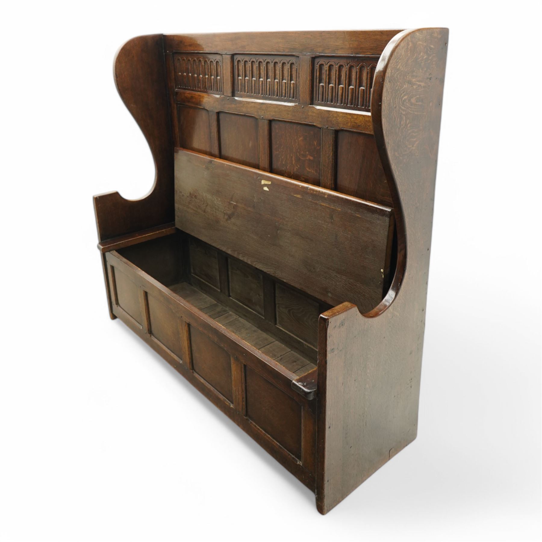 18th century design oak hall bench or settle, tall panelled back decorated with carved arcade, on two shaped end supports, hinged box seat opening to reveal a storage compartment, on a panelled base