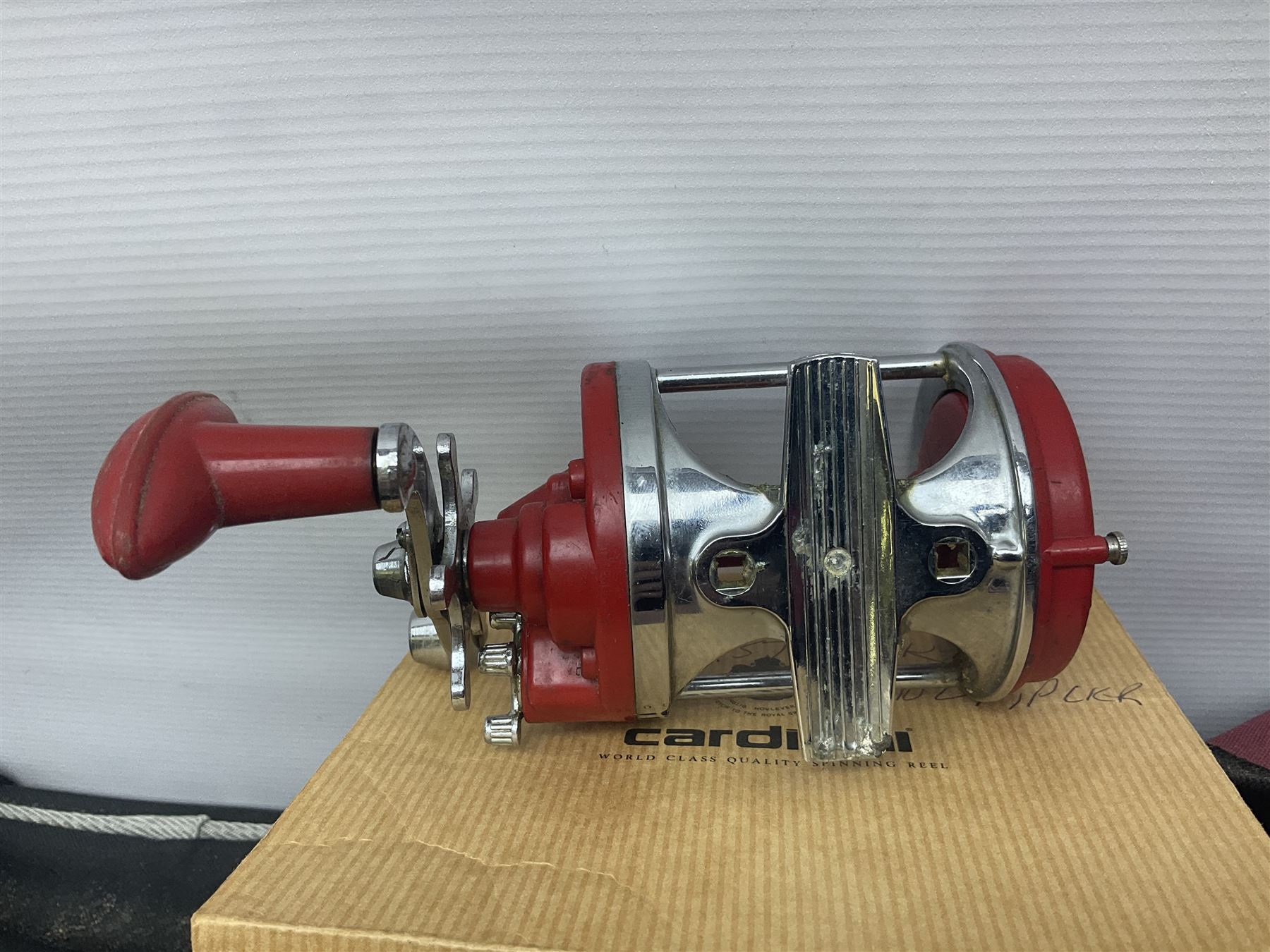 Collection of fishing memorabillia and equipment, including an Allcocks three piece split cane trout fly rod, Shakespeare Salt 3600 surf rod, two tackle bags, Old Red Seastreak multiplier reel, Sportext Saltwater fixed spool reel, fishing dvds, etc