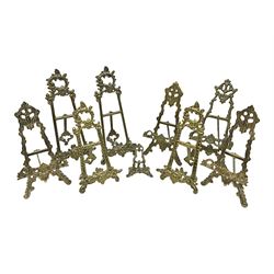 Nine ornate cast brass easel stands of various sizes, H24cm