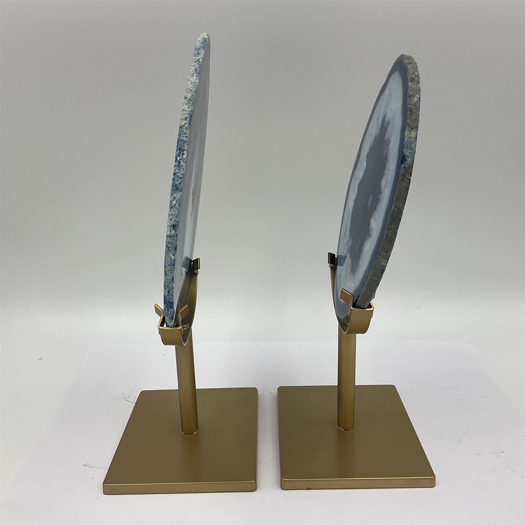 Pair of blue agate slices, polished with rough edges raised upon gilt metal stands, H22cm