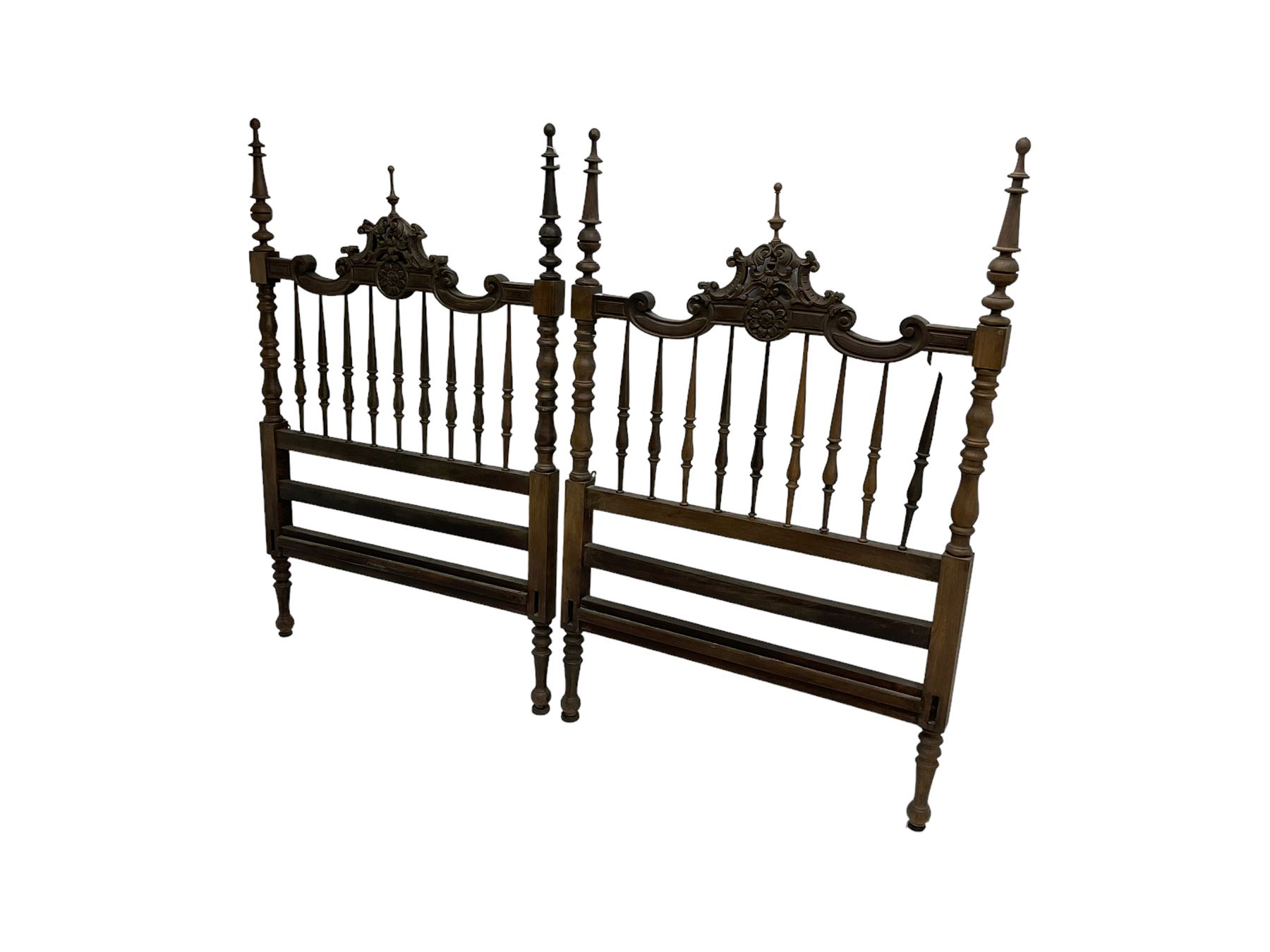 Pair Spanish stained beech single 3' bedsteads, spindle turned backs and carved with scrolling floral decoration 