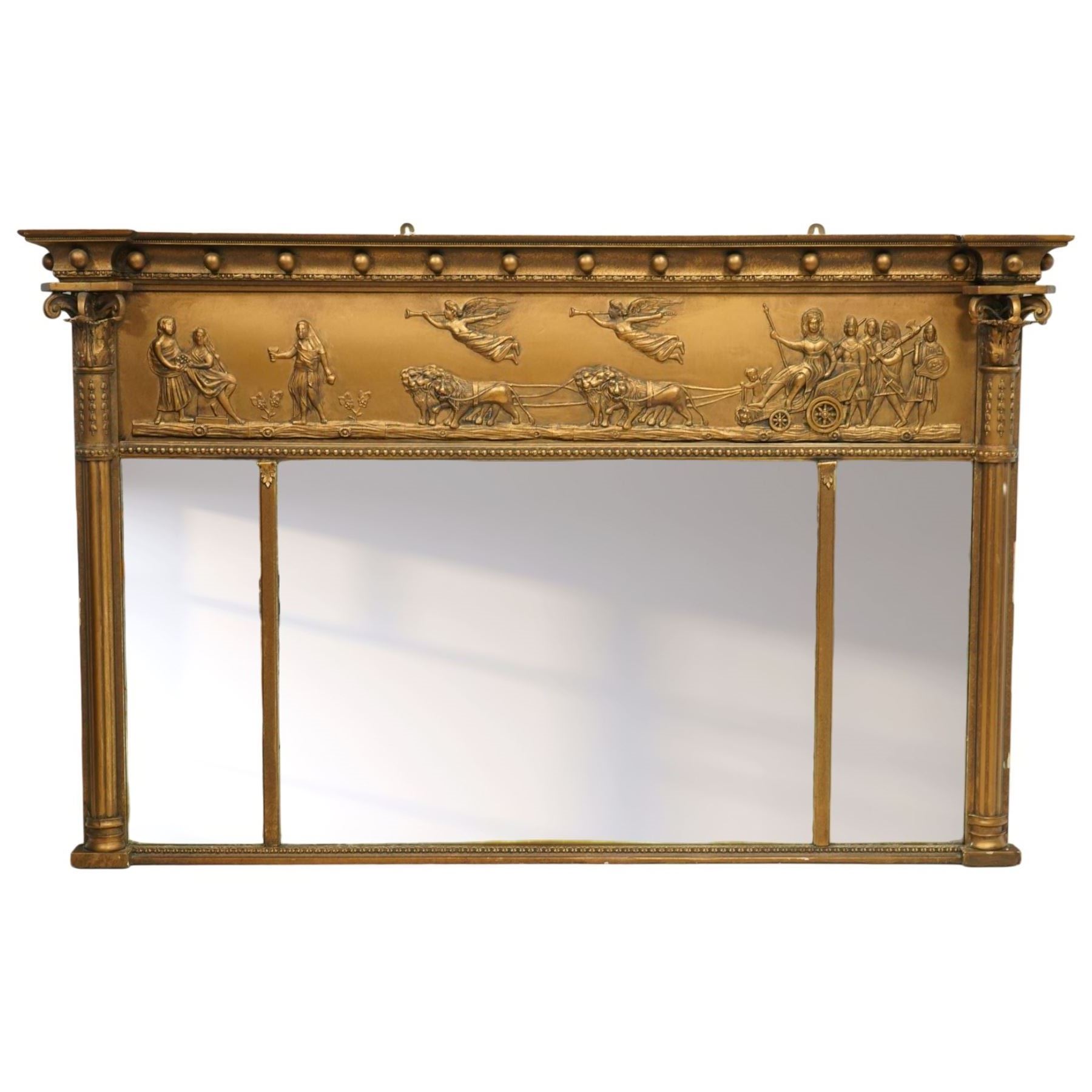 Early 20th-century giltwood tripartite overmantel mirror, rectangular frame with ball decorated cornice above frieze decorated with a classical allegorical depiction of the Triumph of Cybele in a processional chariot drawn by lions, above a beaded moulding and rectangular mirror plate, flanked by plain and reeded pilasters with Corinthian capitals, shafts decorated with pendant garlands  