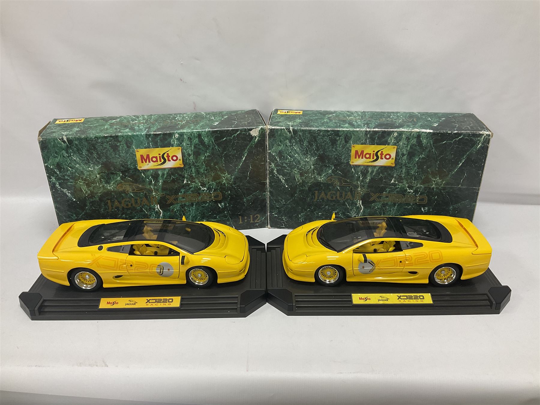 Two Maisto 1:12 scale Jaguar XJ220 ‘Racing’ cars in yellow, both on plinths in original boxes 