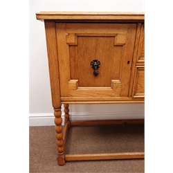  Early 20th century light oak sideboard, two drawers flanked by two cupboards, on bobbin, supports joined by square stretchers, W137cm, H86cm, D46cm  