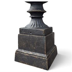 Pair of Neoclassical design black and gilt painted cast iron garden urns of campana form, with egg-and-dart rims and fluted bodies, on knopped stems, fluted socles and stepped square plinth bases