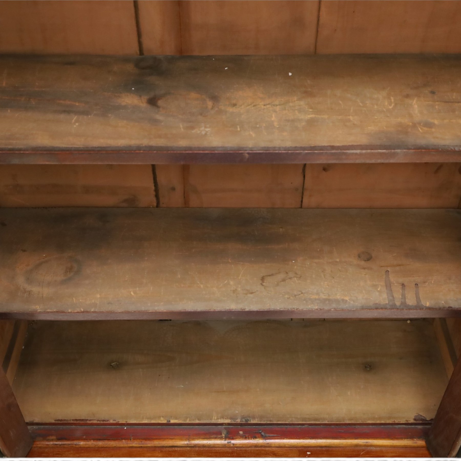 Victorian mahogany bookcase on cupboard of slender proportions, projecting cornice over dentil-frieze, fitted with twin-glazed doors enclosing three shelves, flanked by acanthus corbels, the base fitted with single frieze drawer over panelled cupboard, on skirted base