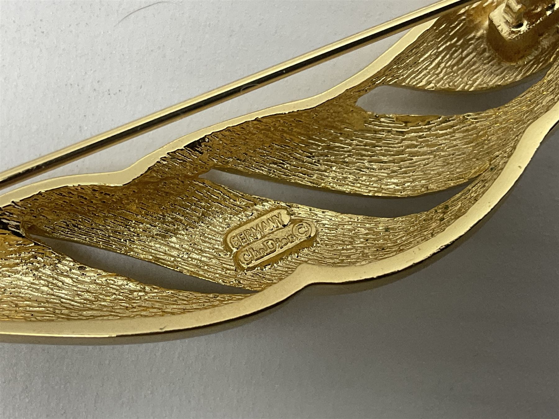 Christian Dior costume jewellery, comprising pair of pearlescent clip on earrings, enamel and paste leaf brooch and a pierced stylised leaf brooch, each stamped Chr.Dior Germany and in original boxes