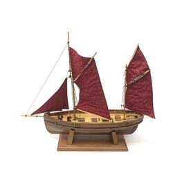 A wooden model of a twin masted fishing yawl, on stand, L60cm. 