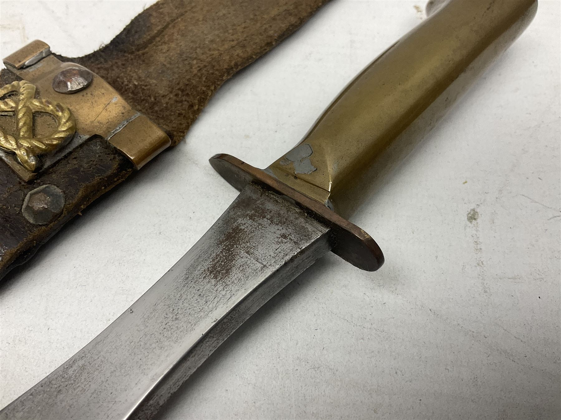 Scratch-built fighting/throwing knife, probably trench art, with 18cm steel spear type blade, plain cross-piece and French Lebel Rifle bayonet grip; in bras mounted studded leather sheath with belt hanger L29.5cm overall