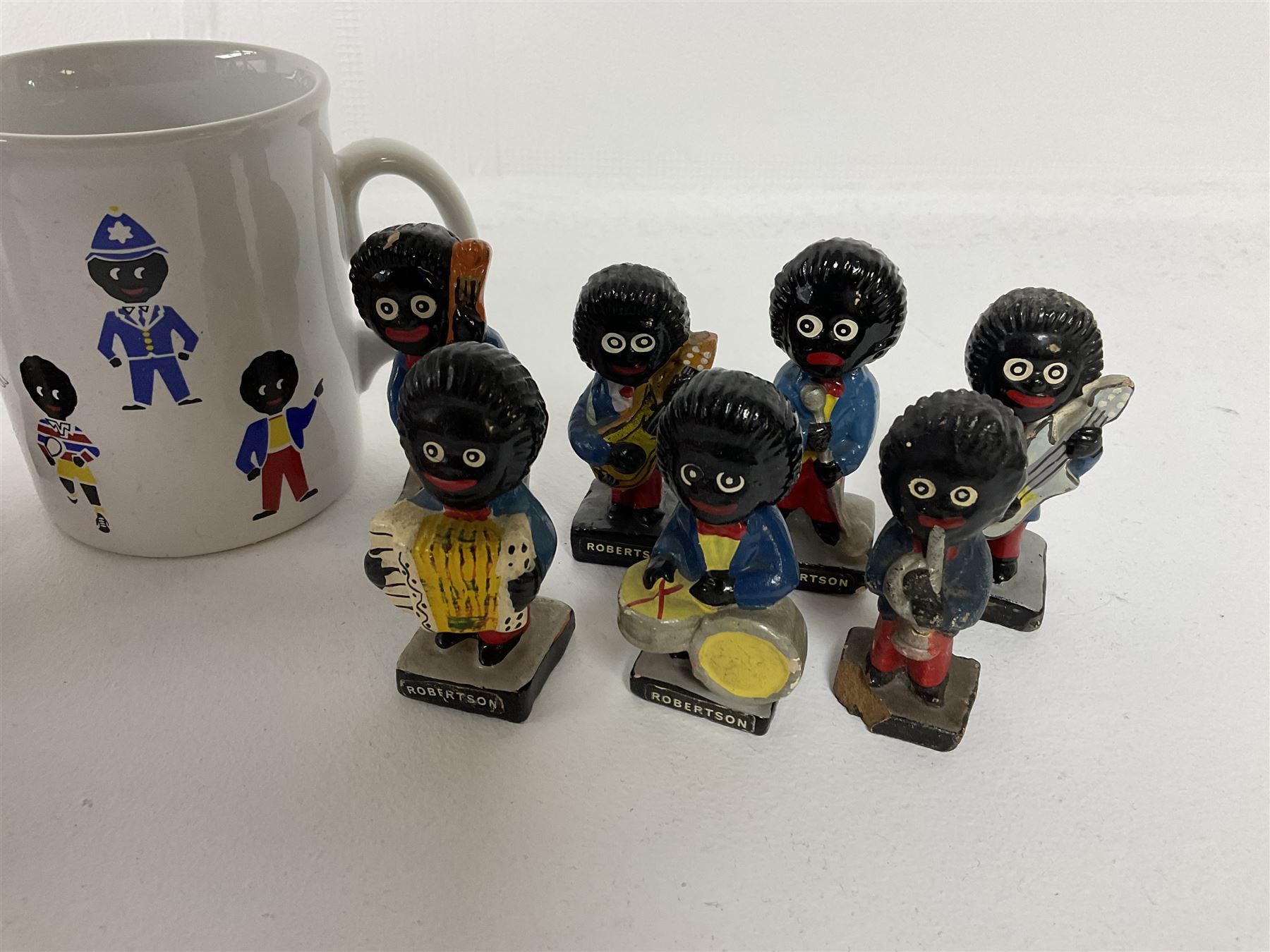 Fourteen Golly Band figures, eight labelled Robertson to base, and TAMS golly mug