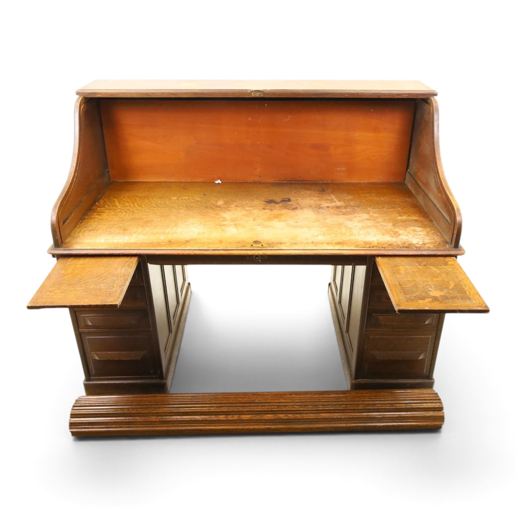 Cutler - Late Victorian oak pedestal tambour desk, the tambour shutter enclosing fitted interior, pull-out writing surface over central kneehole flanked by two pedestals each fitted with four drawers with moulded fronts, pull-out slides above, panelled sides, on moulded plinth base