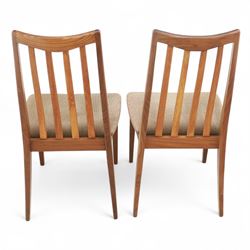 G Plan - mid-20th century teak extending dining table, oval top with integrated extension leaf, raised on tapering legs, together with a set of six slat back dining chairs including two carvers, upholstered in dark green velour (Extends to 210cm)