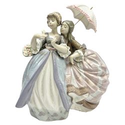 Lladro figure, Southern Charm, modelled as two young ladies one holding a parasol, the other with a basket of flowers on a mahogany wooden base, with original box, no 5700, year issued 1990, year retired 1997, H27cm