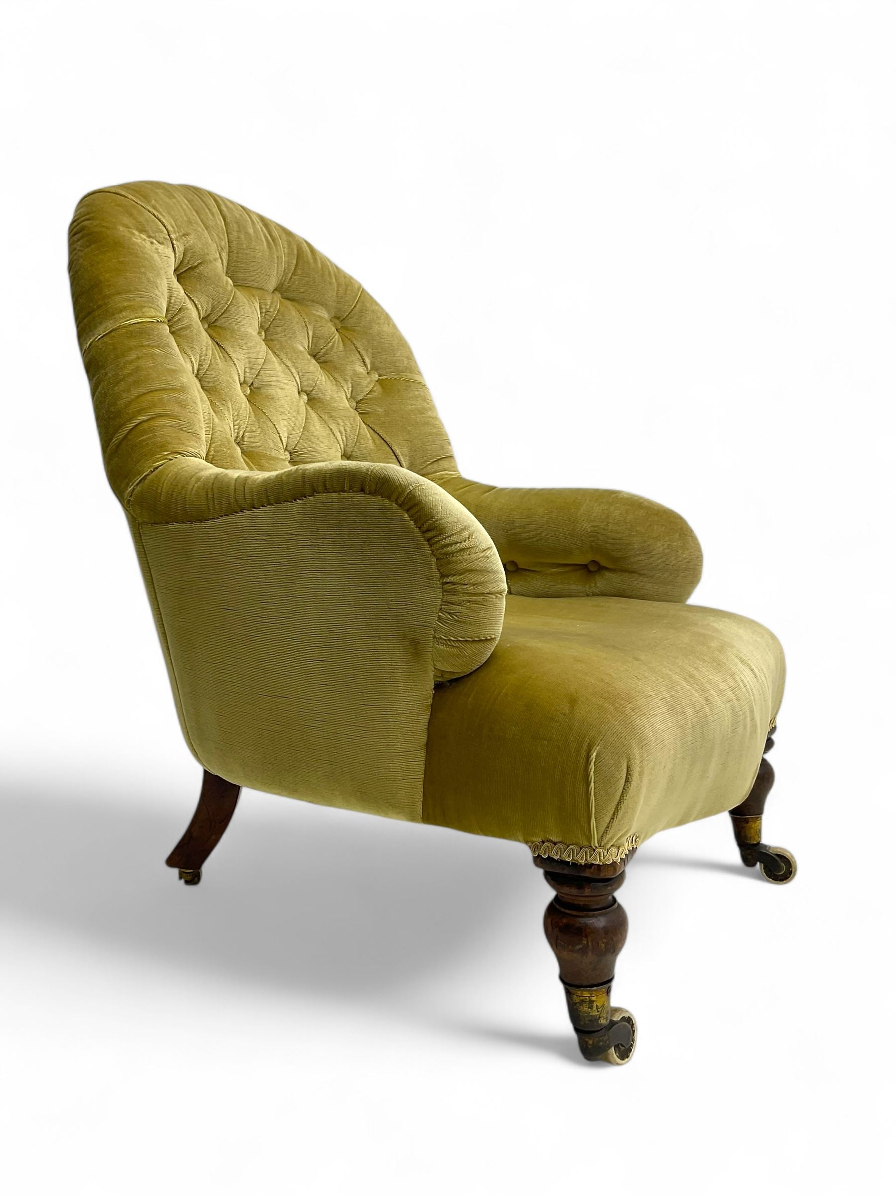Late 19th century button-back nursing chair, upholstered in olive-green velvet, shaped back with padded arms, raised on turned front supports terminating in castors