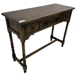 Medium oak side table, rectangular top over three drawers, on turned supports united by H-shaped stretcher rails 