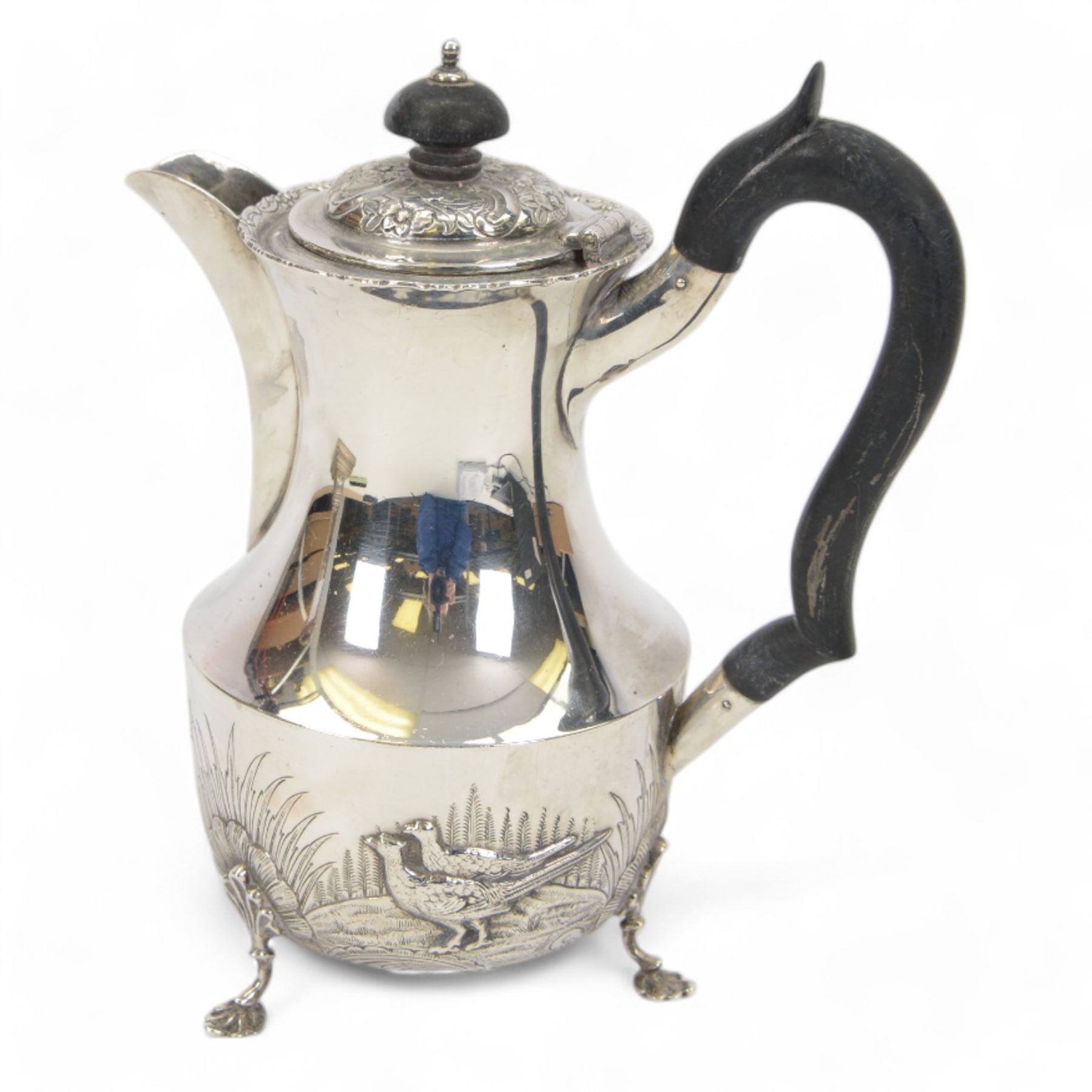 1920s silver hot water pot, with chased and repousse decoration to body depicting pheasants and rabbits in a countryside setting, with Bakelite type handle and finial, upon three palmette mounted feet, hallmarked S Blanckensee & Son Ltd, Birmingham 1928, H22cm