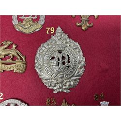 Twenty-two glengarry and cap badges including Argyll & Sutherland, Devonshire, Essex, Hampshire, Royal Berkshire, Northamptonshire, Long Range Desert Group, Royal Corps of Signals, Norfolk, Dorsetshire, East Lancashire etc; mounted on a board for display