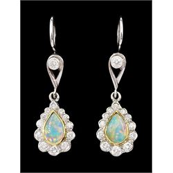 Pair of 18ct gold opal and diamond pendant stud earrings, pear cut opal and round brilliant cut diamond cluster, suspending from a milgrain set single stone diamond