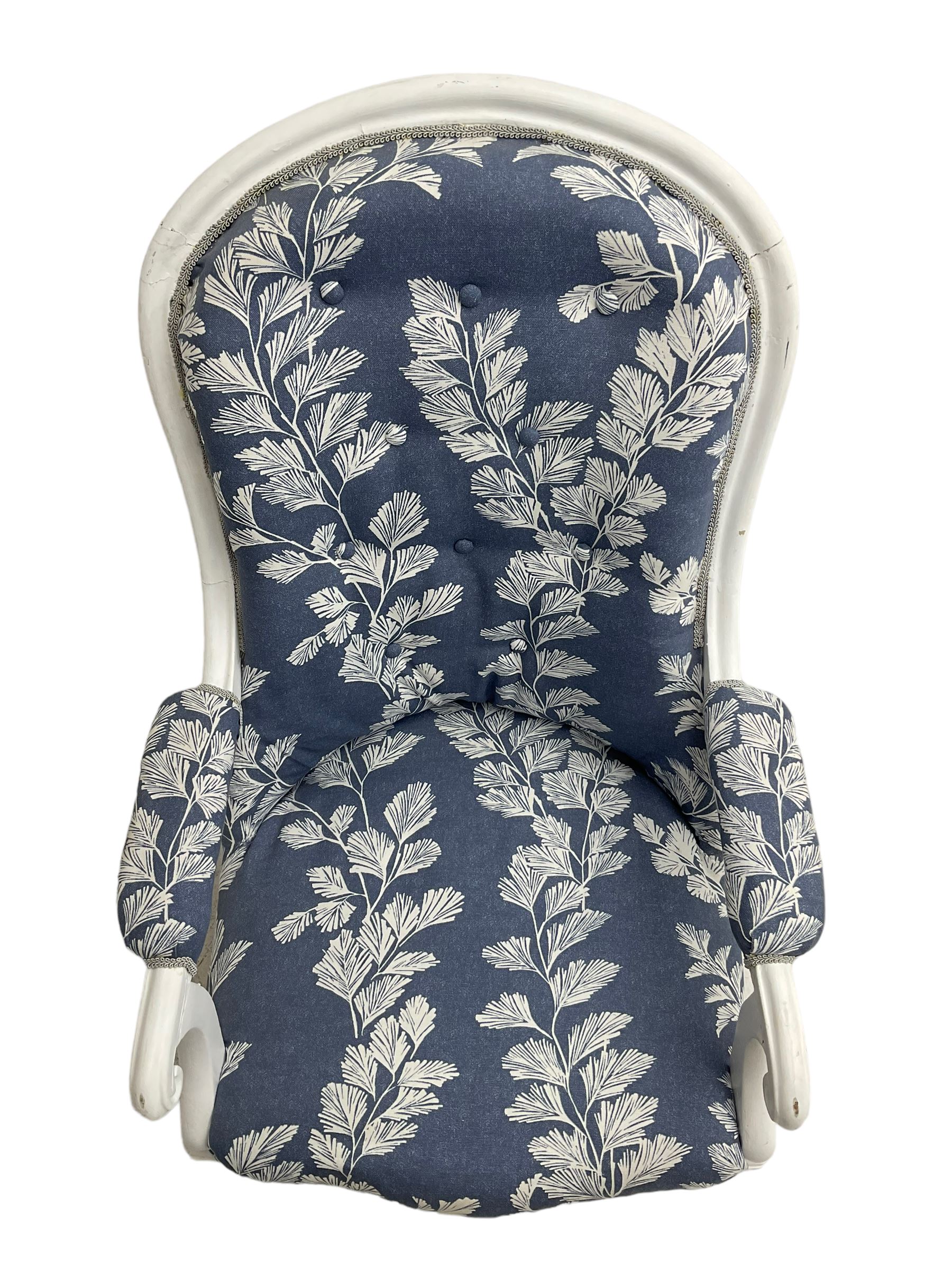 Victorian white painted open armchair, upholstered in blue fabric decorated with trailing leaf pattern, scrolled arm terminals on turned front supports with castors