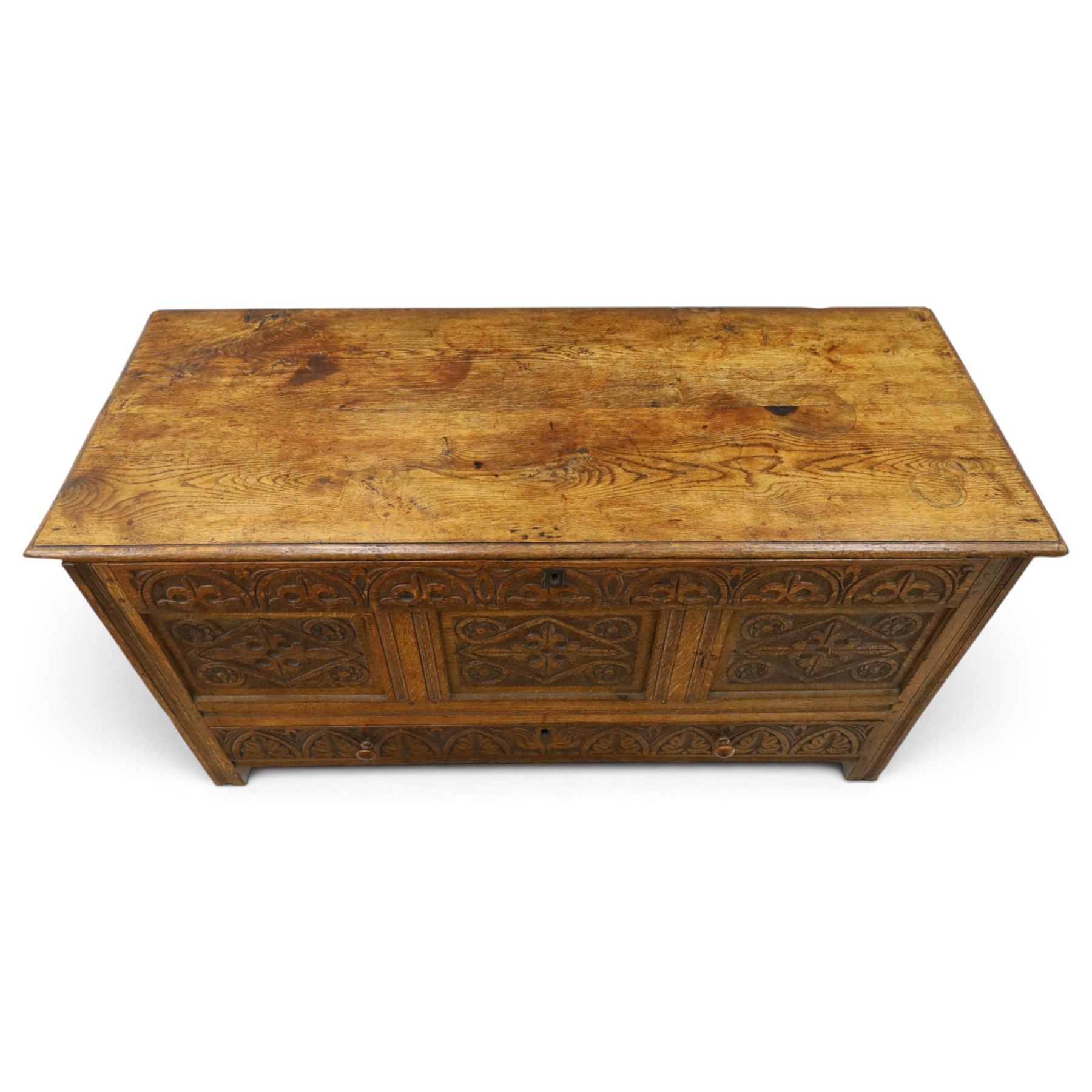 18th century carved oak coffer, rectangular hinged top over a lunette-carved frieze and tracery-style carved triple panelled front, the lower rail carved with repeating anthemion motifs, on square feet