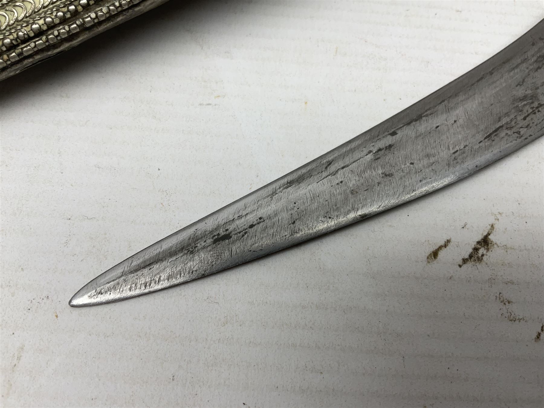 Saudi Arabian khanjar dagger with 29.5cm curving double edged  steel blade; white metal and copper mounted horn grip; in white metal mounted brass and leather scabbard incorporating embroidered leather wearing strap