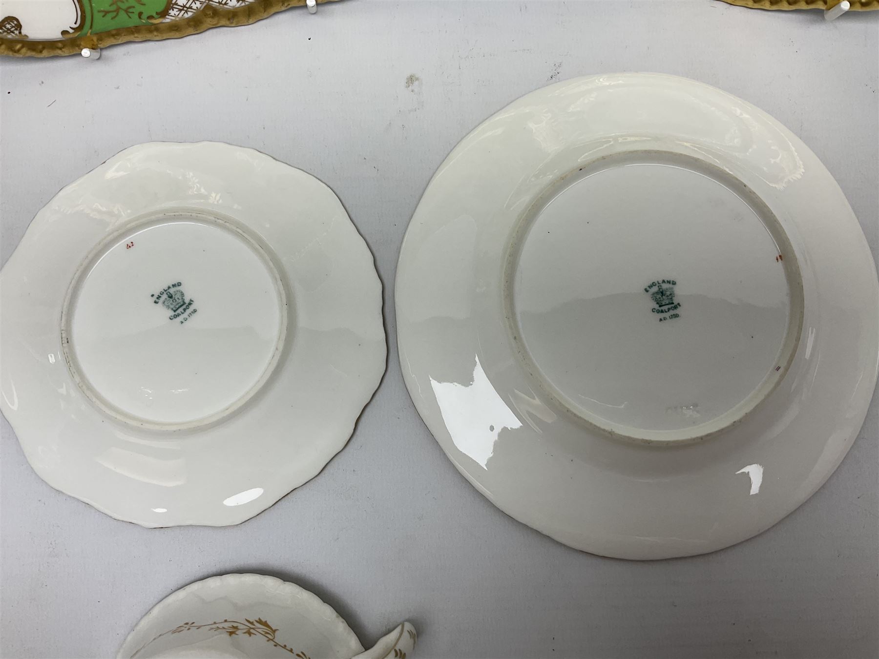 Coalport green batwing pattern tea wares, decorated with finely enamelled floral sprays within gilt reserves, comprising teacup trio, twin handled cake plate and side plate, pattern no Y2665, together with a Coalport for Harrods cup and saucer similarly decorated, the saucer with stamped mark beneath 'Manufactured for Harrods Ltd, Brompton Rd London', all with green Coalport AD 1750 marks beneath, largest W31cm (7)