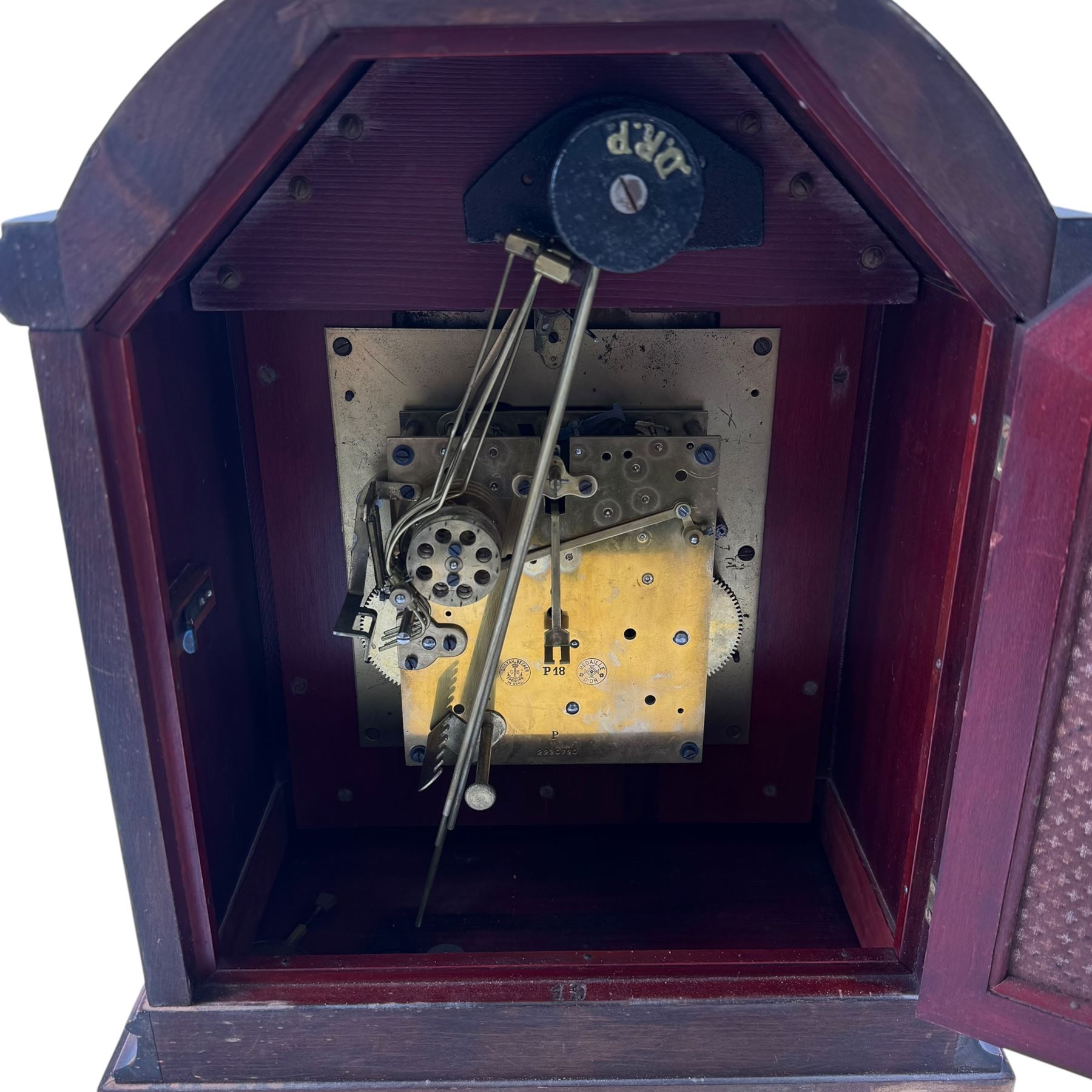 Gustav Becker, German 20th century 8-day mahogany cased mantle clock, break arch mahogany case with a round topped door flanked by reeded pilaster with Ionic capitals and raised on a stepped plinth, the dial with engraved Roman numerals, with steel fleur di Lis hands, and  chime /silent dial, H43cm