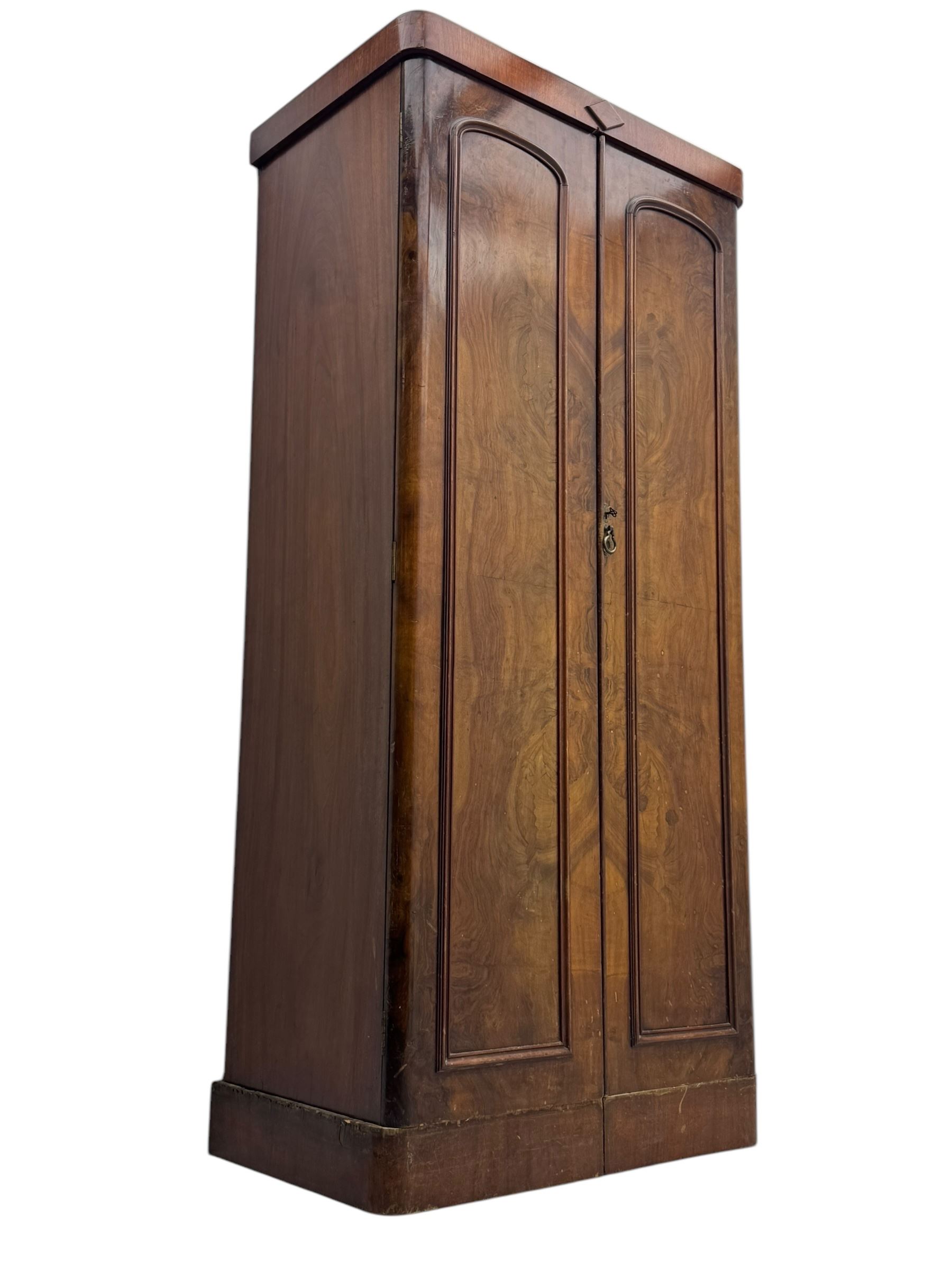 Victorian figured walnut single wardrobe, the moulded cornice with a central diamond motif over a pair of arched panelled doors with striking book-matched veneers, enclosing a fitted interior with hanging rail and hooks, on a plinth base